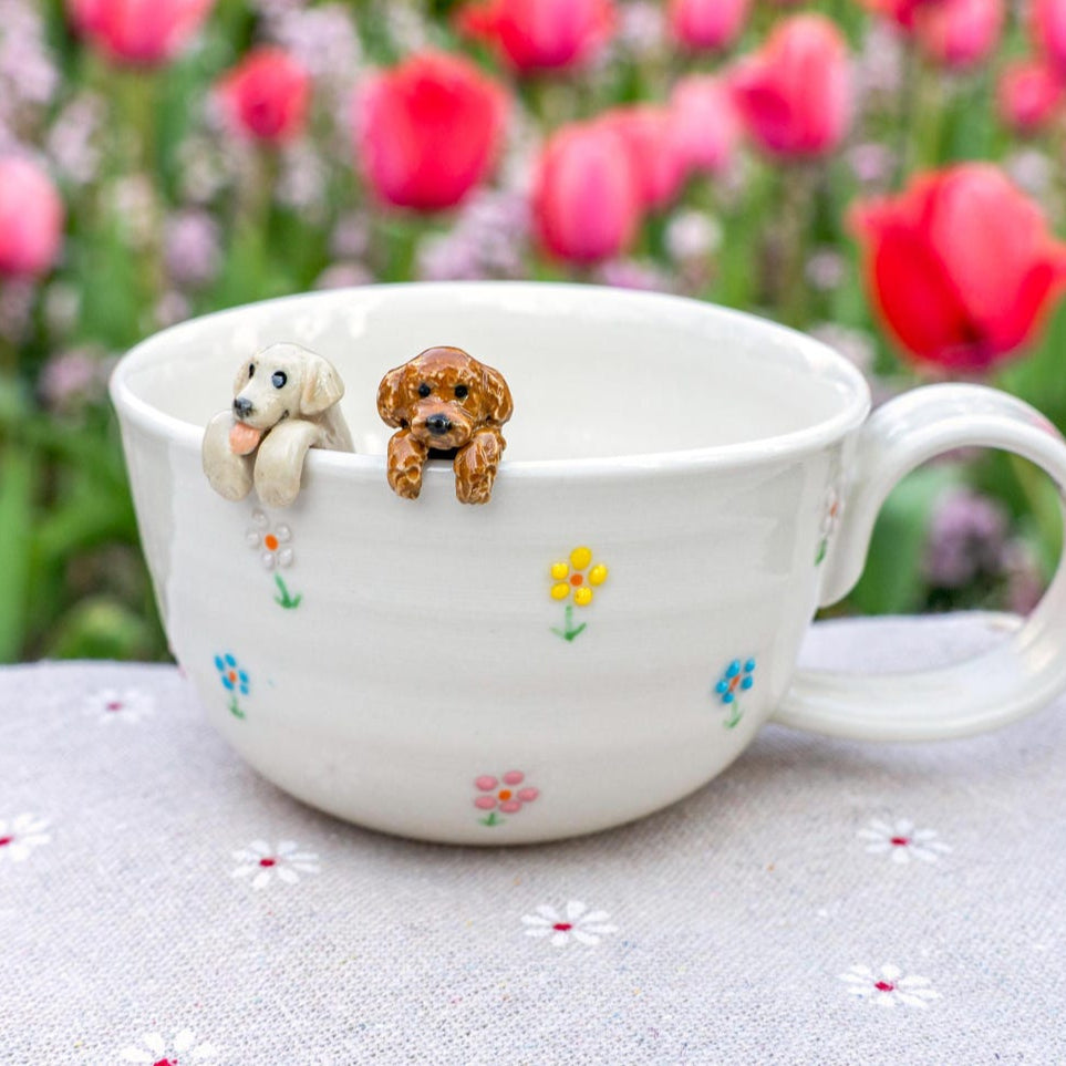 Ceramic mug with dog figurines on a floral background